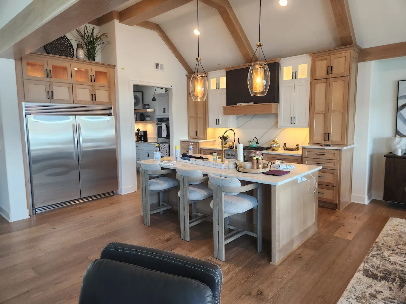 Custom cabinetry with natural wood beams and island